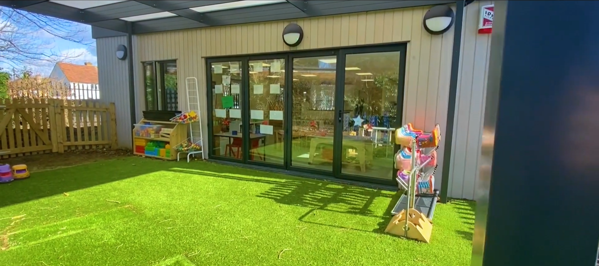 Landscape shot of the back doors of a classroom leading out onto a grass area at Molehill Primary Academy.